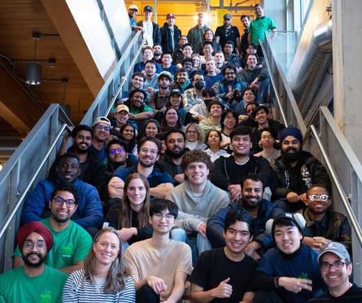 Large group of students sitting on open stairs.