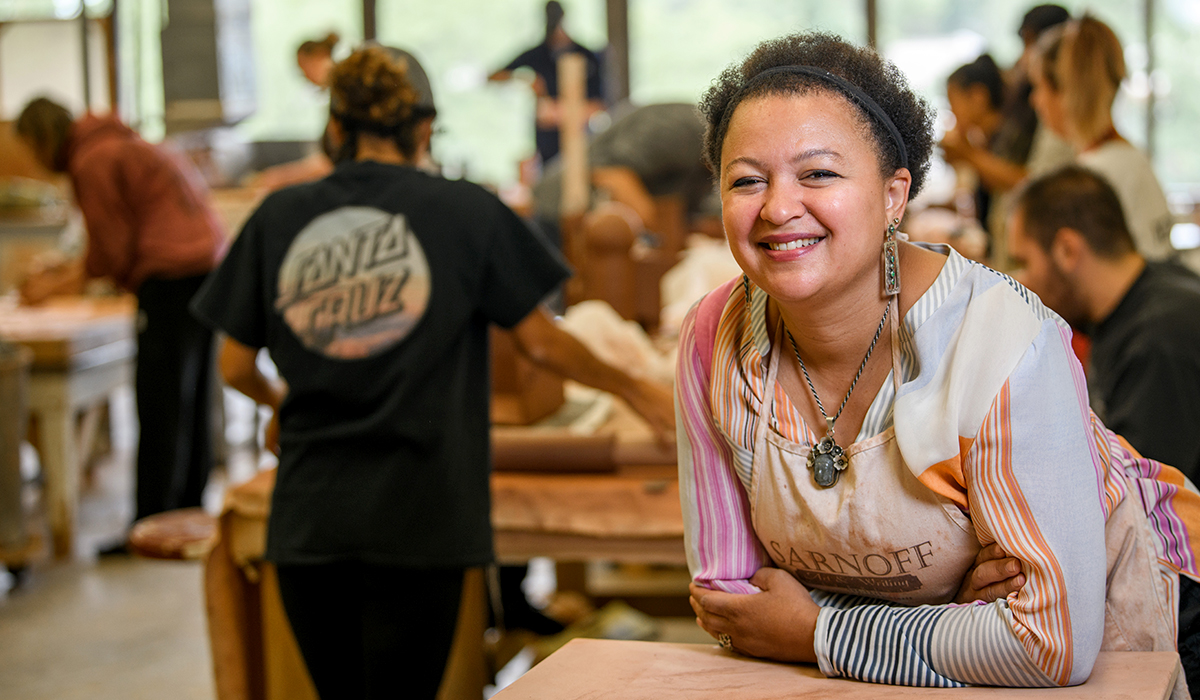 Closeup of Palmer in industrial classroom with students in background.