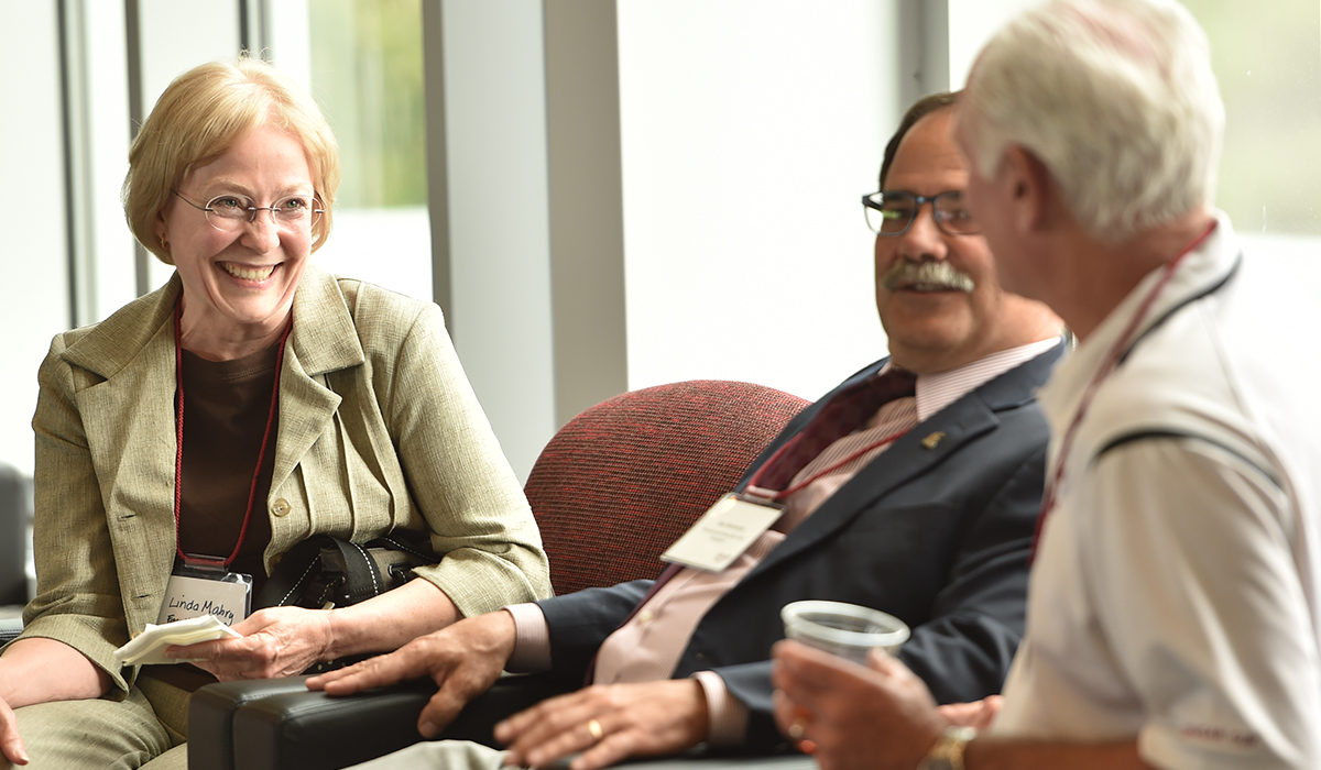 Dan Bernardo and others seated and conversing with one another.